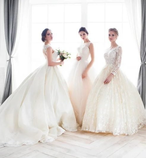 Three women in wedding dresses by John Emily Studio