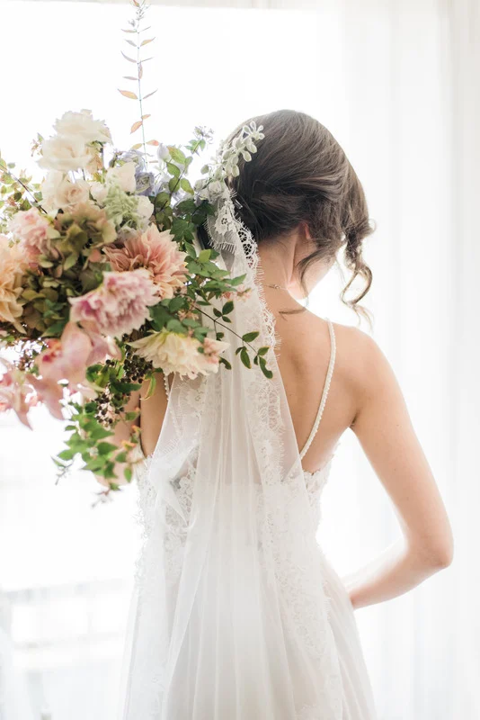 A bride in a white wedding dress holding a bouquet of flowers.