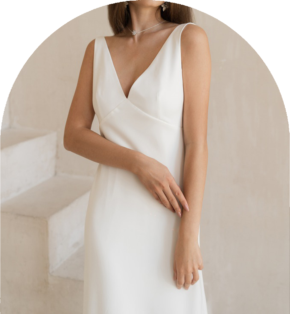 A woman in a white dress wearing a gown by John Emily Studio.
