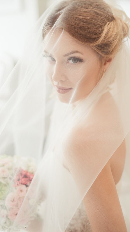 A bride in a white wedding gown, radiating elegance and joy.