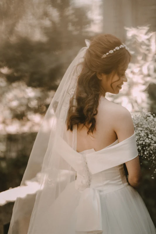 A woman in a bridal gown glancing back towards the camera.