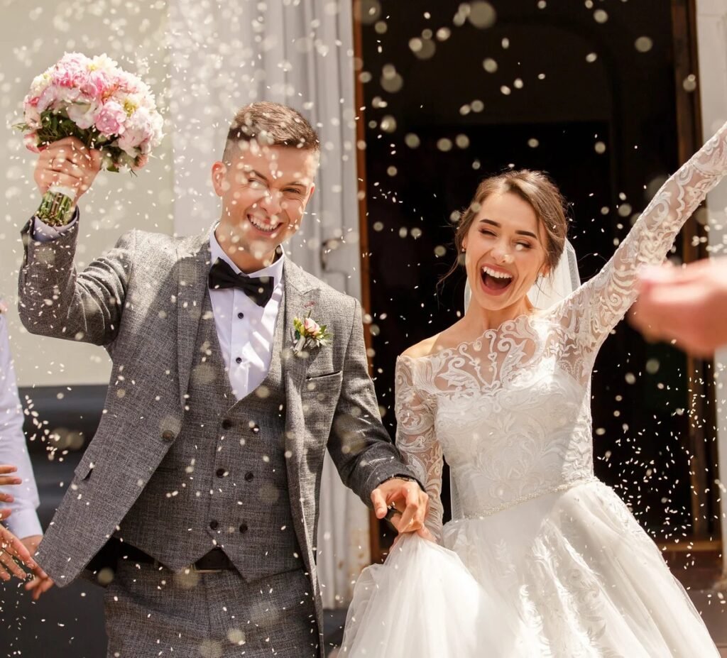 A Bride and groom happily throw confetti at their wedding.