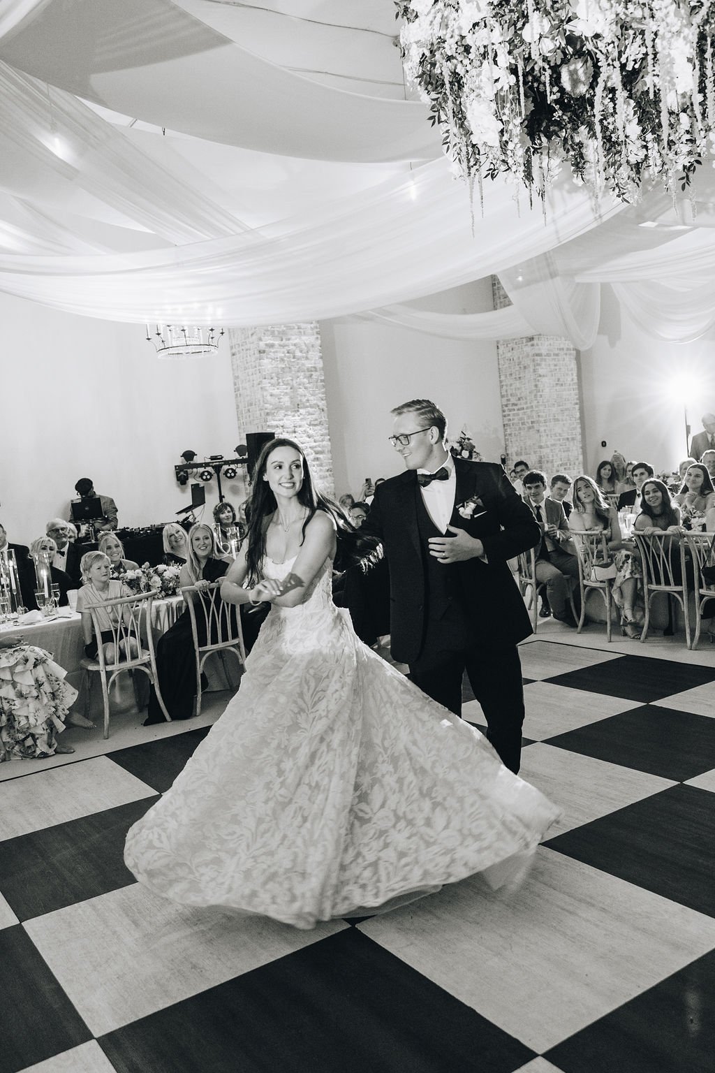 Black-and-white photograph of a bride and groom dancing at their reception